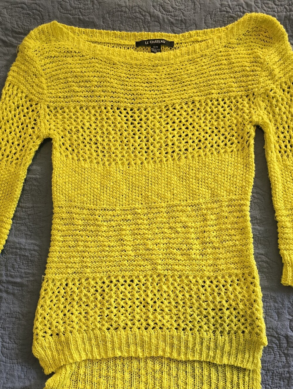 Château crochet knit top features a boat neckline and a high-low hemline.